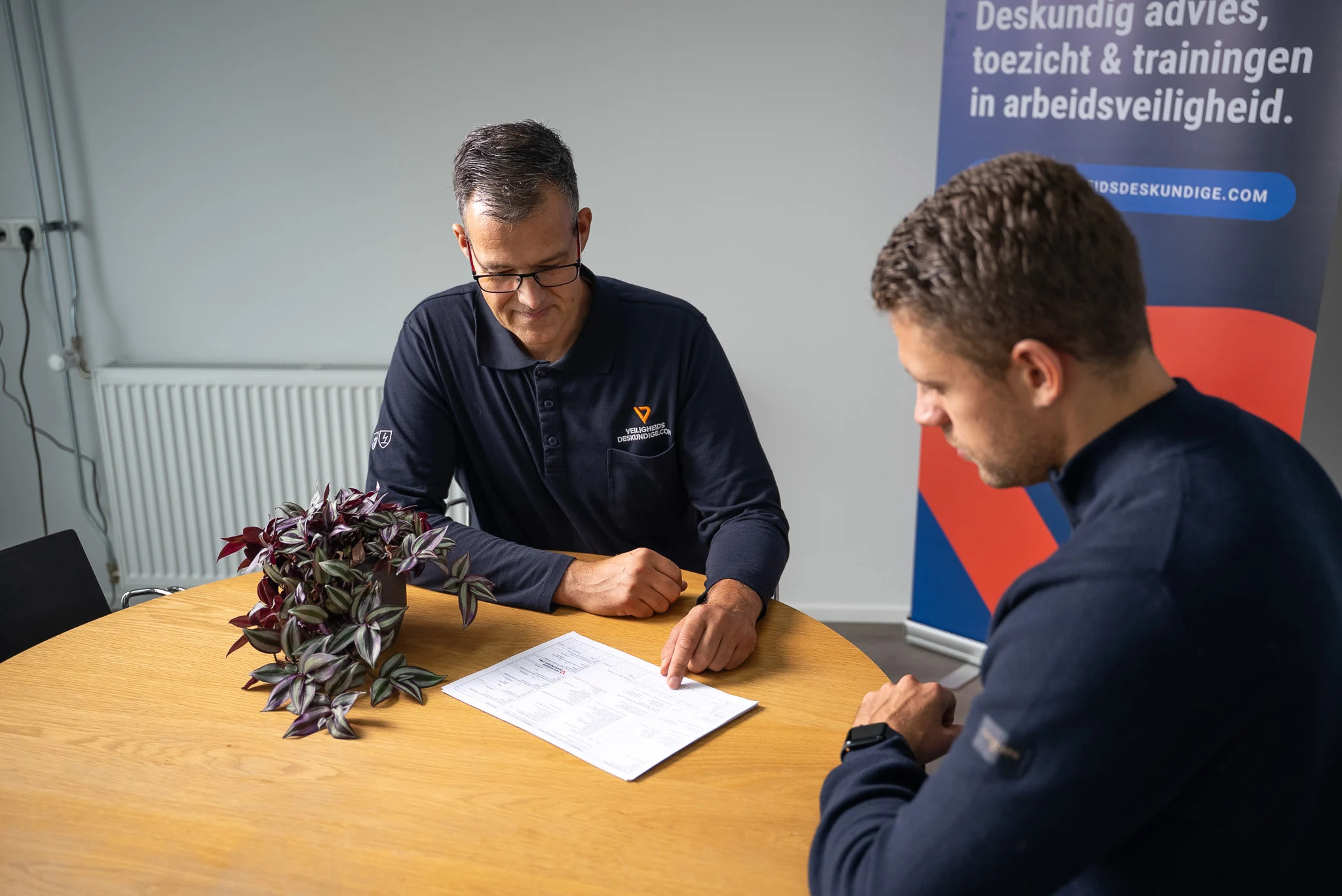 Persoonlijke uitleg tijdens VCA-begeleiding aan tafel